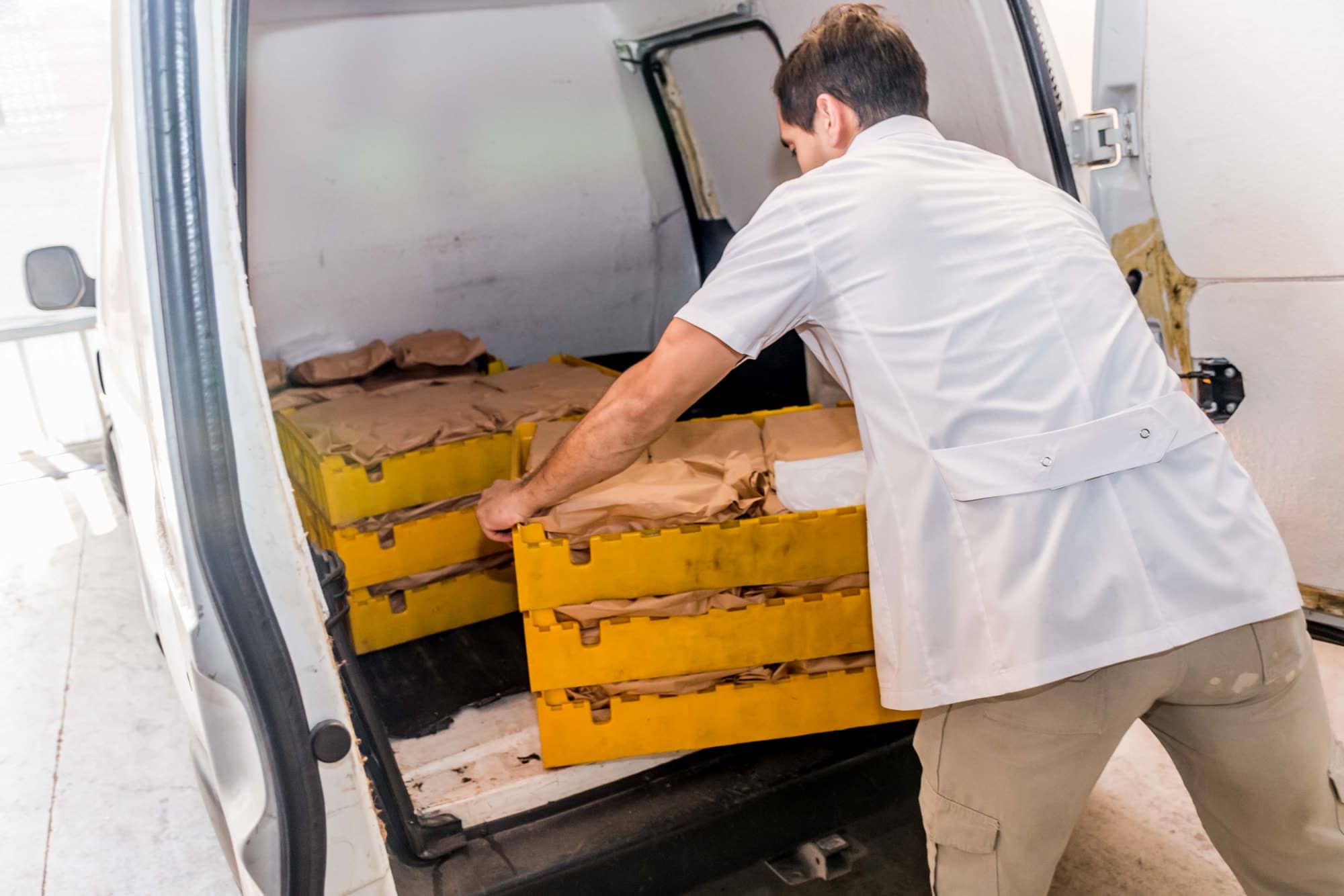 Carga de cajones con viandas en una camioneta de reparto de La Pacha
