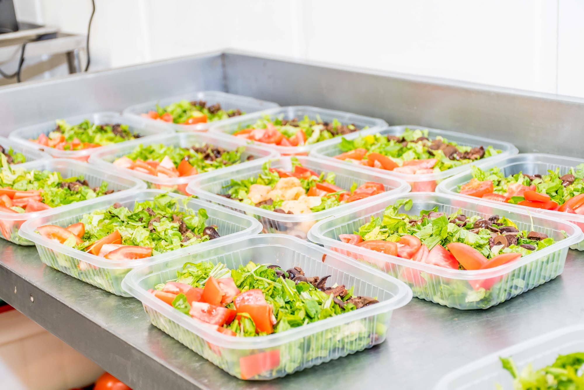 Viandas de ensalada fresca en bandejas individuales listas para termosellar
